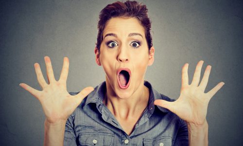 excited surprised woman screaming isolated on gray wall background